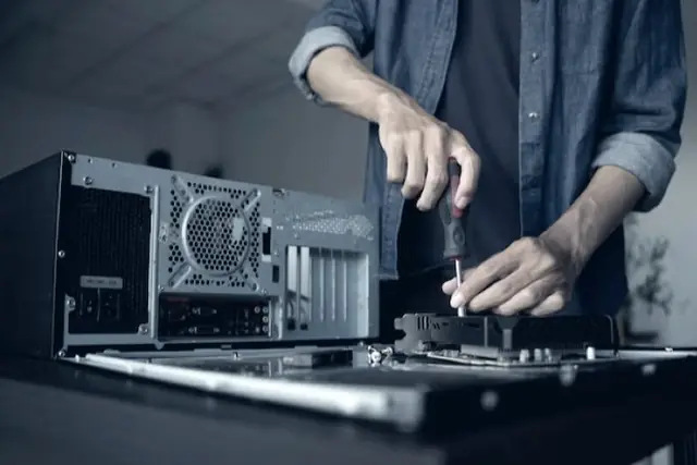 Técnico reparando un computador de escritorio con un destornillador